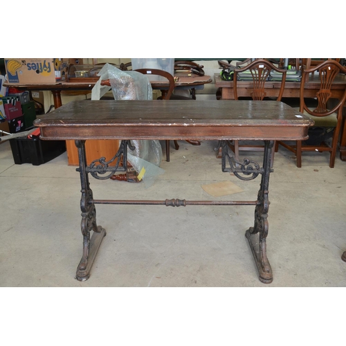 483 - Early C20th pub table, rectangular wooden top on pierced scrolled tapering cast iron end supports wi... 