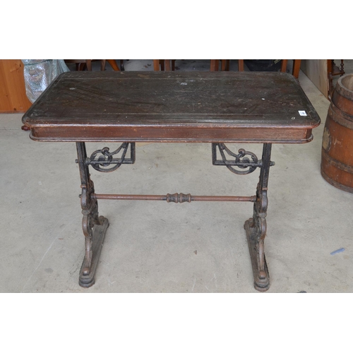 484 - Early C20th pub table, rectangular wooden top on pierced scrolled tapering cast iron end supports wi... 