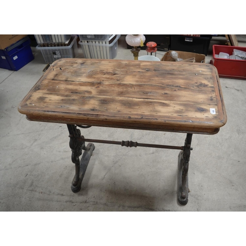 486 - Early C20th pub table, rectangular wooden top on pierced scrolled tapering cast iron end supports wi... 