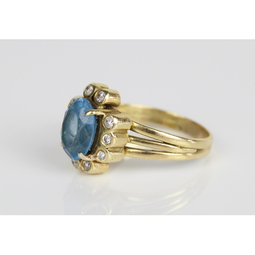 225 - 18ct yellow gold cluster ring, the central oval cut blue stone surrounded by brilliant cut diamonds,... 