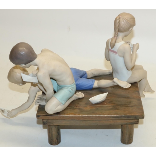 743 - Lladro porcelain group Paper Boats, matte porcelain figurine of three children seated playing with s... 