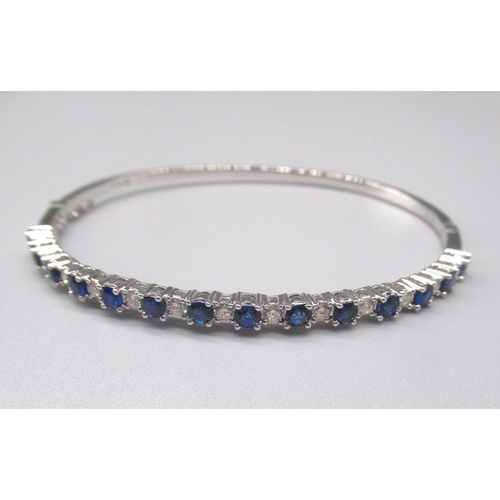 212 - 18ct white gold bangle with open box clasp, set with diamonds and sapphires, stamped 750, 11.8g