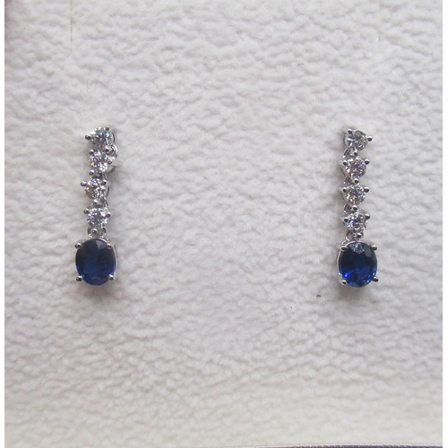 214 - 18ct white gold diamond and sapphire drop earrings, each set with four brilliant cut diamonds and an... 