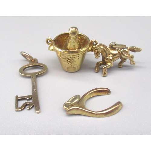 34 - Four 9ct yellow gold charms including a 21st key, champagne in bucket, lucky wishbone and pony, all ... 