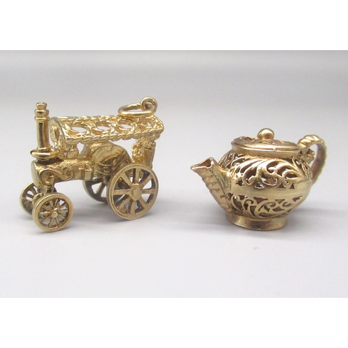 39 - 9ct yellow gold steam engine charm, stamped 375, and a 9ct yellow gold filigree teapot, stamped 375,... 