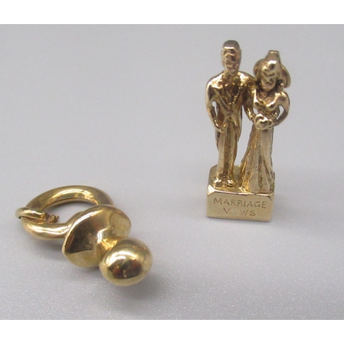 883 - Two 9ct yellow gold charms including a dummy and a wedding scene stamped 'marriage vows', both stamp... 