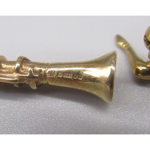 884 - 9ct yellow gold clarinet charm, a 9ct yellow gold saxophone brooch, both stamped 375, 5.8g, and a ye... 