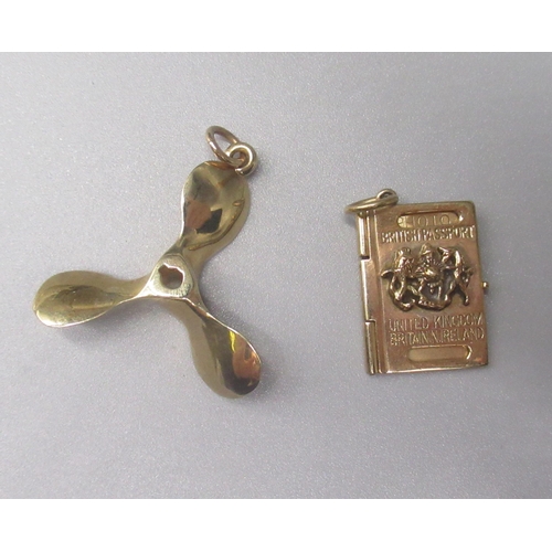 890 - Two 9ct yellow gold charms including a propeller and a passport, both stamped 375, gross 9.9g