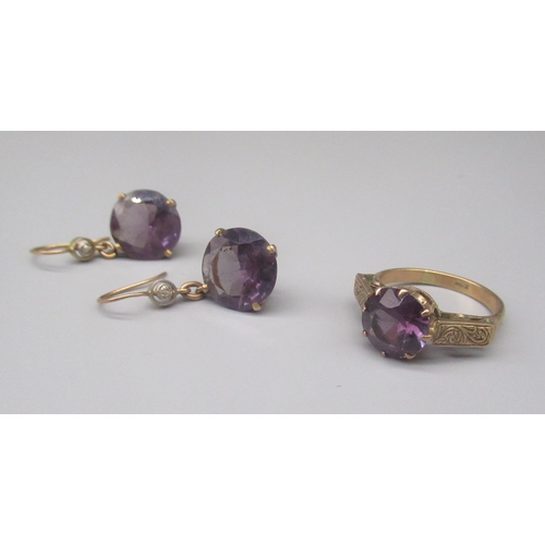 896 - 9ct yellow gold ring set with round cut purple/blue stone on engraved shoulders, stamped 9ct, size O... 