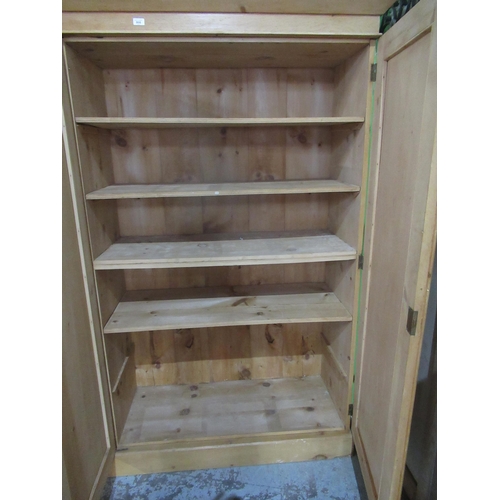 808 - Stripped pine cupboard, moulded cornice above three panel doors with shelved interior, plinth base, ... 