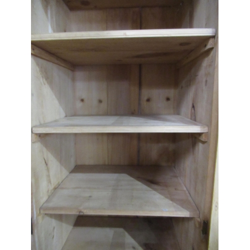 809 - Stripped pine cupboard, moulded cornice above three panel doors with shelved interior, plinth base, ... 