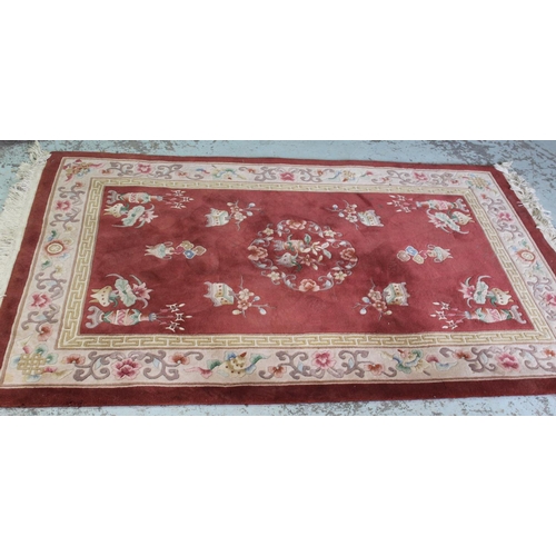 539 - Chinese rug decorated with flower vases on a Salmon ground, 200cm x 130cm