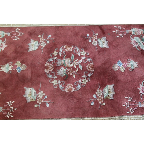 539 - Chinese rug decorated with flower vases on a Salmon ground, 200cm x 130cm