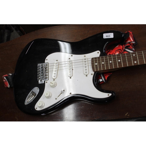 803 - Squier Fender Strat six string black finish electric guitar, with stand, mike and music stands, (4)