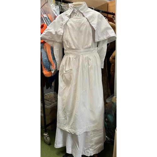 295 - Collection of WWI style nurses white dresses in 2 boxes, 5 dark blue jackets/blazers, and a hat