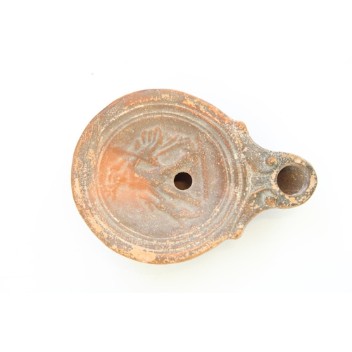 775 - C1st CE Ancient Cypriot Roman terracotta oil lamp, central well decorated in relief with a hunter wi... 