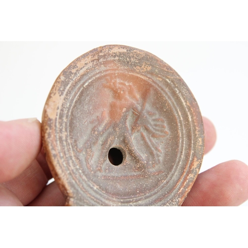 775 - C1st CE Ancient Cypriot Roman terracotta oil lamp, central well decorated in relief with a hunter wi... 