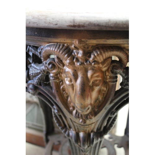 1476 - Cast metal three legged pub table with pine circular top the ornate design to legs including rams he... 