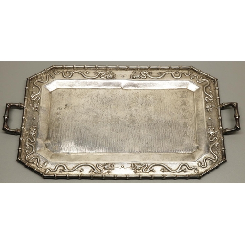 1203 - Early C20th Chinese hammered silver canted rectangular tray, border relief decorated with dragons wi... 