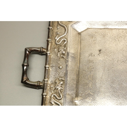 1203 - Early C20th Chinese hammered silver canted rectangular tray, border relief decorated with dragons wi... 