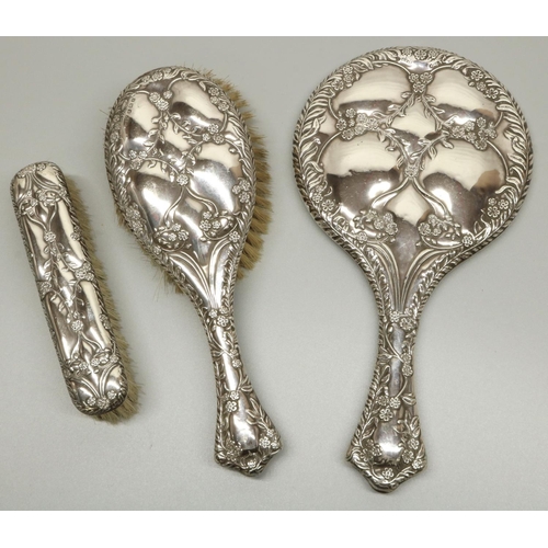 1187 - Edward VII - George V hallmarked silver hand mirror and two brushes with floral and gadrooned decora... 