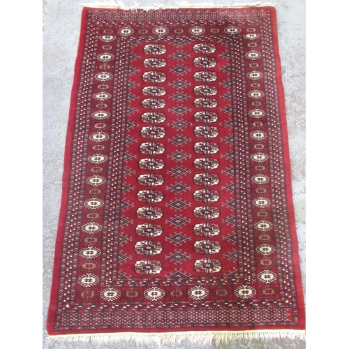 1446 - Bokhara pattern red ground wool rug, field with octagonal medallions, in hooked stylized striped rep... 