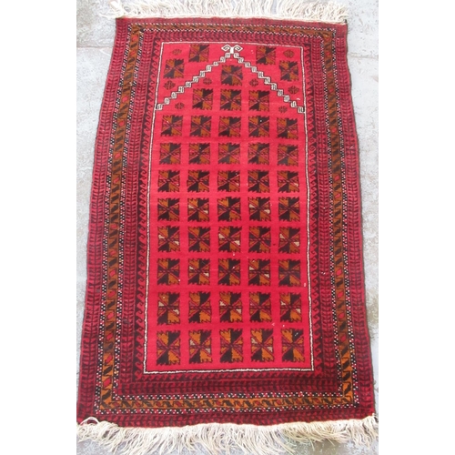 1447 - Afghan red ground wool prayer rug, stepped field with geometric medallions, in repeating stylized st... 