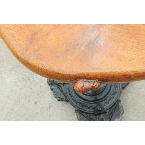 1416 - Robert Mouseman Thompson of Kilburn - a bar table, oval figured oak top on slender cast iron baluste... 