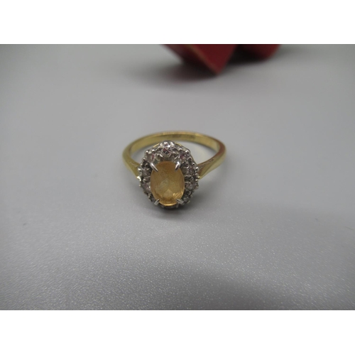 20 - 18ct yellow gold and platinum cluster ring, the central oval cut pale yellow stone surrounded by a h... 