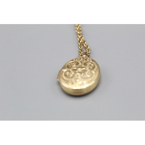 771 - 9ct yellow gold oval pendant locket with floral and scroll decoration, stamped 375, on 9ct yellow go... 