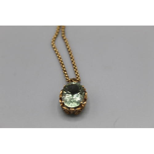 774 - 9ct yellow gold pendant set with oval cut pale green stone in ornate mount, on 9ct yellow gold belch... 