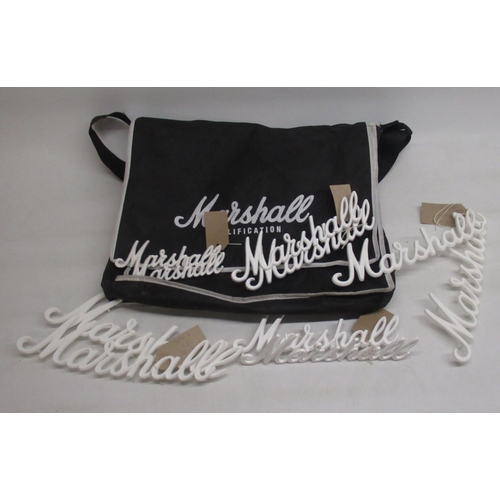 421 - Ten  Marshall white script name plates for amplifiers and a branded Marshall bag