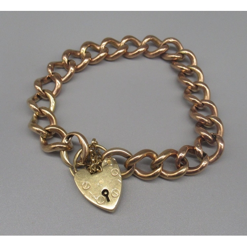 601 - Yellow metal charm bracelet, unmarked, with 9ct yellow gold heart padlock, stamped 375, 22.3g