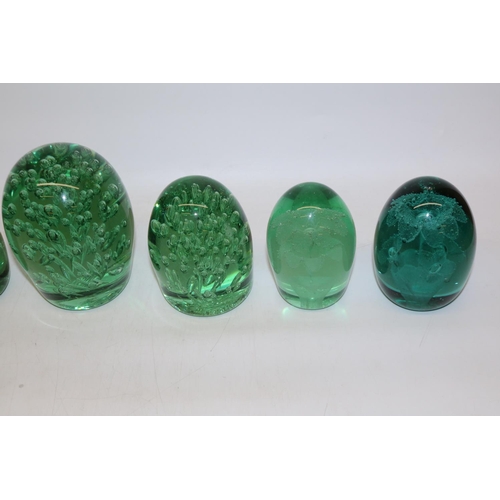 417 - Group of seven green glass dumps, four with internal flowers, max H13cm.