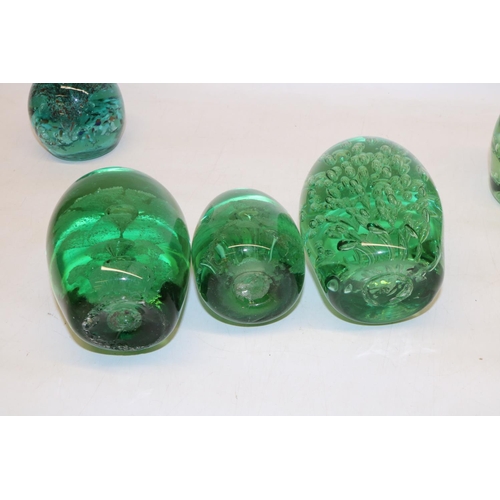 417 - Group of seven green glass dumps, four with internal flowers, max H13cm.