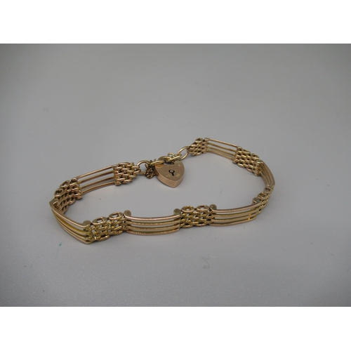 601 - Yellow metal four bar gate bracelet, no visible hallmark, with 9ct yellow gold padlock heart clasp, ... 