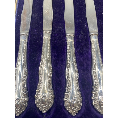 57 - Set of six butter knives with hallmarked Sterling silver repousse handles, marks worn, in fitted cas... 