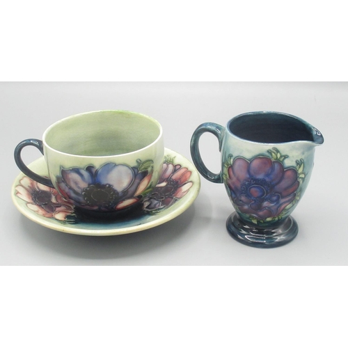 205 - Moorcroft Pottery: Anemone pattern cup, saucer and jug, tube lined with red/purple flowers on green ... 