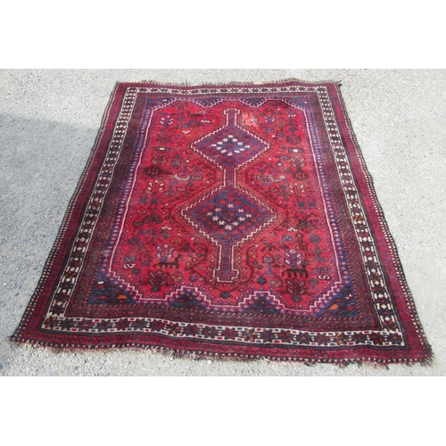 753 - Red ground Afghan rug, the field with stepped joined medallion and geometric figures and foliage wit... 