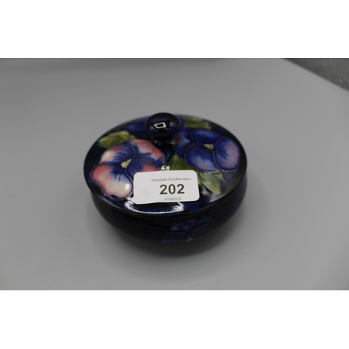 202 - Moorcroft Pottery: Pansy pattern trinket pot and cover, tube lined with purple and pink flowers on a... 