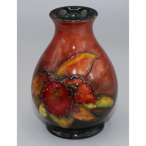 207 - Moorcroft Pottery: Floral pattern flambe vase, tube lined with red and green flowers on red ground, ... 