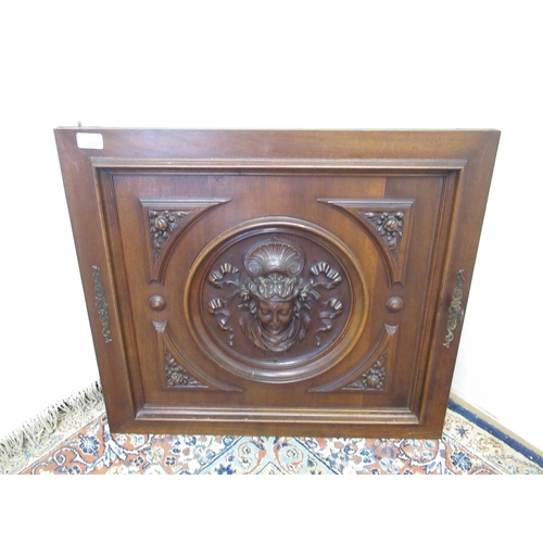 772 - Walnut door panel, centered by a ribbon tied mask head in a moulded roundel with oak leaf carved spa... 