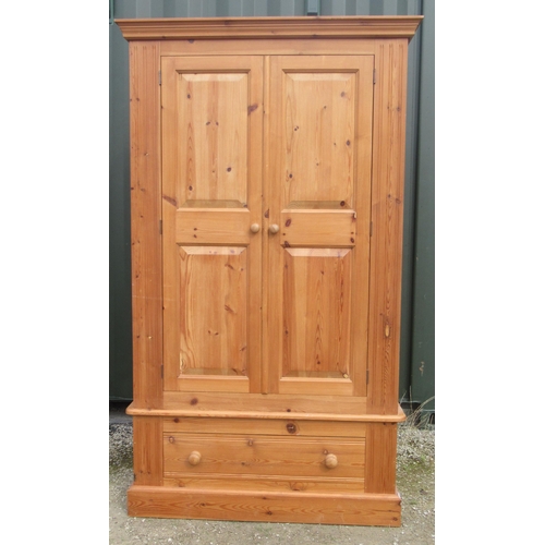 796 - Modern pine wardrobe, moulded cornice above two twin panel doors above a drawer with turned wooden h... 