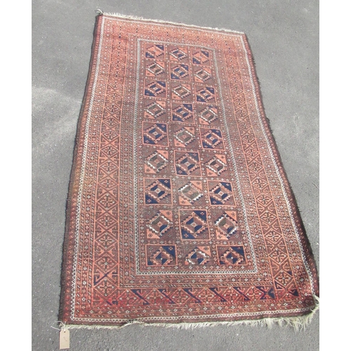 842 - C20th Caucasian pattern rust ground rug, central field with fifteen medallions within a geometric pa... 