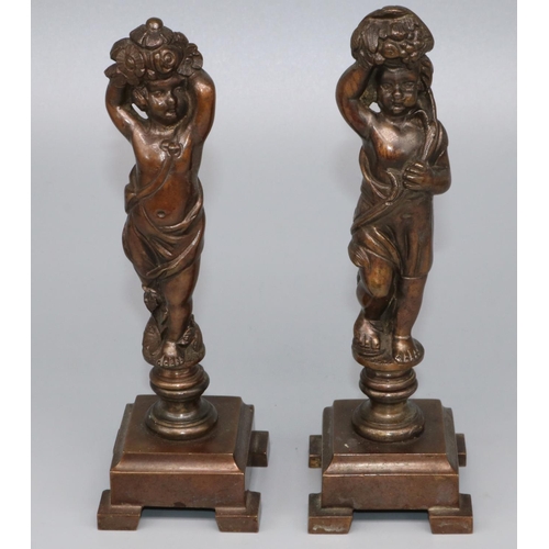 1114 - Pair of patinated bronze models of standing cherubs supporting flower filled cornucopia, on stepped ... 