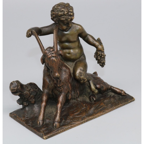 1113 - After the Antique - a small patinated bronze model of a faun with grape bunch astride a goat, on nat... 