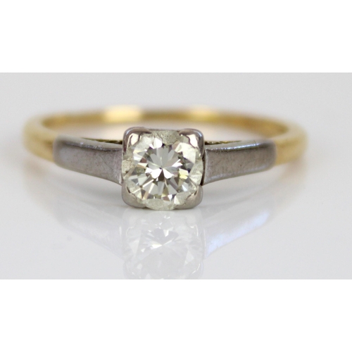 1014 - 18ct yellow and white gold solitaire ring, the round cut diamond in white gold claw setting, on tape... 