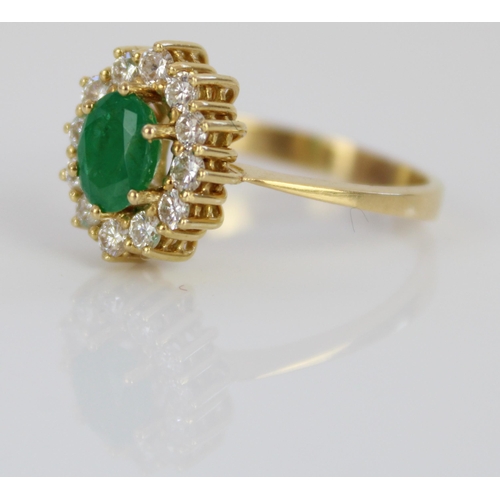 1011 - Yellow metal emerald and diamond cluster ring, the central oval cut emerald surrounded by a halo of ... 