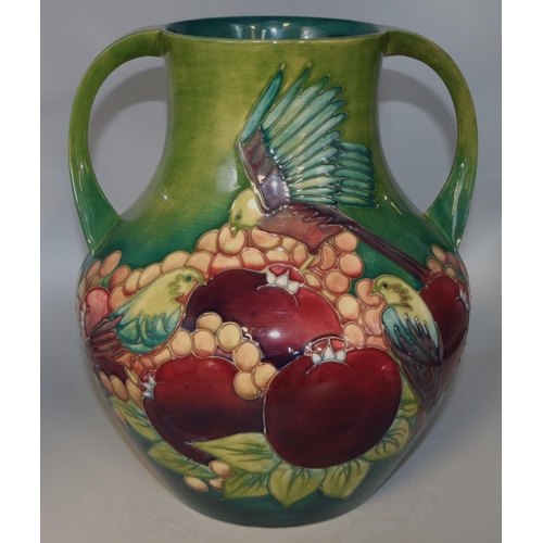 1141 - Moorcroft Pottery: Finches pattern twin handled vase, tubelined decoration of birds and fruit on a g... 