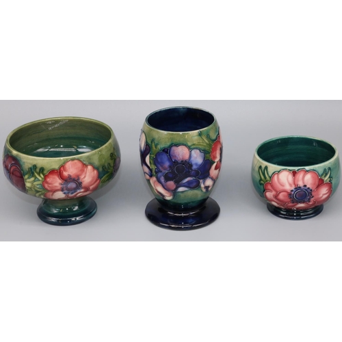 1145 - Moorcroft Pottery: three Anemone pattern vases, tubelined decoration of purple and pink flowers on g... 